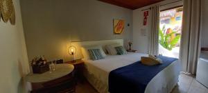 a bedroom with a large bed and a window at Pousada Vila Mato Verde in Morro de São Paulo