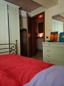 a bedroom with a red bed and a kitchen at Il Gioiellino di Modena - Elegant Apartment[☆☆☆☆☆] in Modena