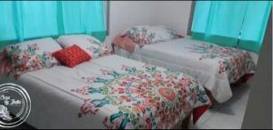 Dos camas en una habitación con flores. en Casa la india, en Ciudad Valles