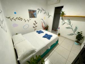 a bedroom with a bed with blue bows on it at Aurora Hostel in Pipa