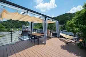 a deck with a table and a hammock on a boat at SEN.RETREAT CHIKATSUYU in Tanabe