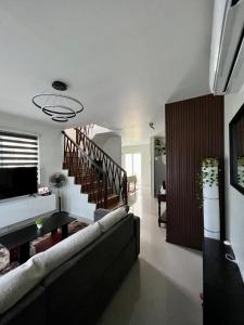 a living room with a couch and a staircase at Home in Aspire Prime Residences - Block 1 Lot 39 in San Fernando