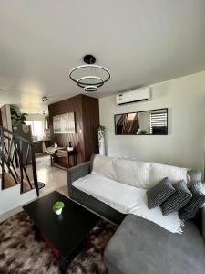 sala de estar con sofá y mesa en Home in Aspire Prime Residences - Block 1 Lot 39, en San Fernando