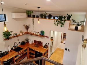 a kitchen with a wooden table and some plants at Adventurer's Chest - Taiwawe in Hotwater Beach