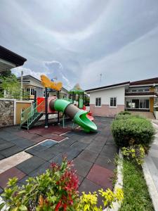 a playground with a green slide in a yard at Home in Aspire Prime Residences - Block 1 Lot 39 in San Fernando