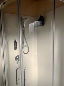 uma cabina de duche com uma cabeça de chuveiro na casa de banho em Pinewood Motels em Fairlie