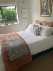 a bedroom with a large bed with a window at Absolute waterfront in Raglan