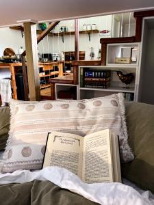 a book laying on a pillow on a bed at Adventurer's Chest - Taiwawe in Hotwater Beach