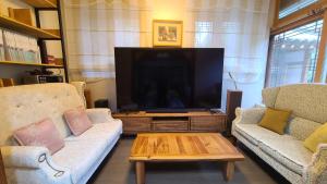 a living room with two couches and a flat screen tv at Ever Healing House in Namugil