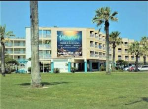 a large building with palm trees in front of it at Cozy one bedroom condo in Corpus Christi