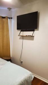 聖體市的住宿－Cozy one bedroom condo，卧室配有壁挂式平面电视。