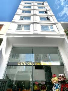 een hoog wit gebouw met een bord erop bij Luu Gia Hotel in Nha Trang