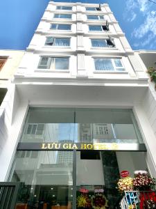 a tall white building with a sign on it at Luu Gia Hotel in Nha Trang