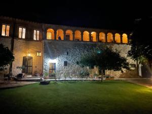 - un grand bâtiment en pierre avec une cour la nuit dans l'établissement Le Logge Di Silvignano, à Campello sul Clitunno