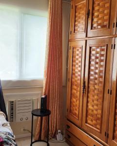 1 dormitorio con un gran armario de madera y una ventana en Semana Santa no Rio de Janeiro, en Río de Janeiro