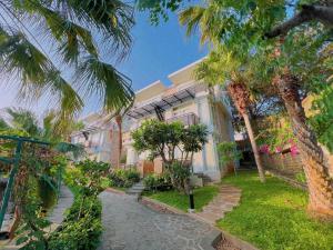 ein Haus mit Palmen davor in der Unterkunft Seaside Resort Vung Tau in Vũng Tàu