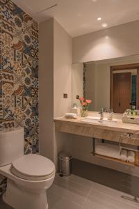 a bathroom with a toilet and a sink at Seaesta Nha Trang Hotel in Nha Trang