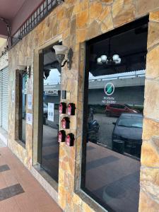 una tienda frente con una gran ventana con coches en Ilhamku Inn, en Kampong Kemaman