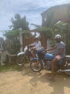 two people sitting on motorcycles in front of a house at Un Dia Boutique Resort in Playas
