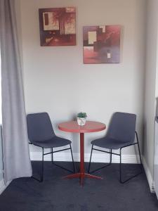 two chairs and a table in a room with a table at Hope Street Apartments in Dunedin