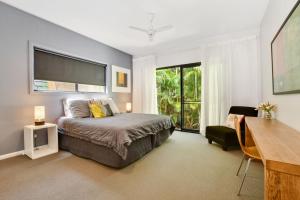 a bedroom with a bed and a desk and a window at Bessou in Charlotte Bay