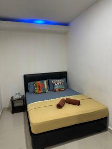 Cama en habitación con luz azul en Ilhamku Inn, en Kampong Kemaman
