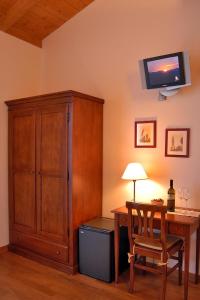 Habitación con escritorio, armario y TV. en Agriturismo Gaggioli Borgo Delle Vigne, en Zola Predosa