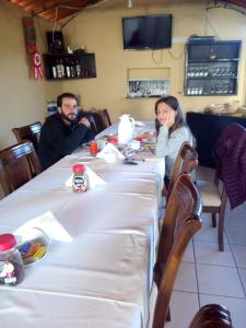 卡巴納孔德的住宿－La Posada del Conde Lodge，坐在桌子上的男人和女人