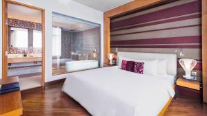 a bedroom with a large bed and a large mirror at Grand Mercure Danang in Danang