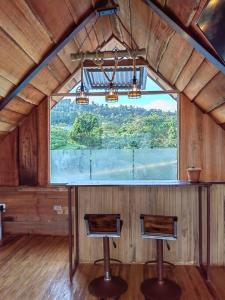 Habitación con 2 sillas y ventana grande. en Casa Rústica Pura Vibra, en Alajuela