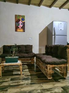 ein Wohnzimmer mit 2 Sofas und einem Kühlschrank in der Unterkunft Casa Rústica Pura Vibra in Alajuela