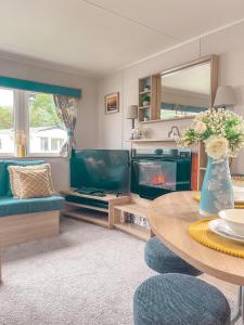 a living room with a table and a fireplace at Spacious Caravan - Thorpe Park Cleethorpes in Humberston