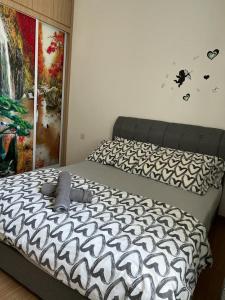 a bed in a bedroom with a zebra print sheets at Homelite Resort in Miri