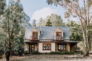 a house in the woods with a metal roof at Apple Tree Cottage - An Idyllic Country Reset in Eurunderee