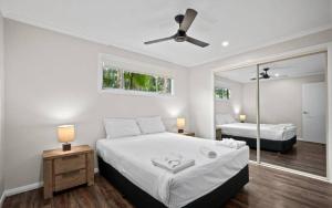 a bedroom with two beds and a mirror at Sapphire Beach Holiday Park in Coffs Harbour