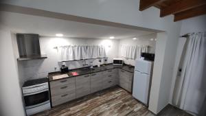 cocina con electrodomésticos blancos y suelo de madera en DON ALBERDI ALOJAMIENTOS en San Rafael