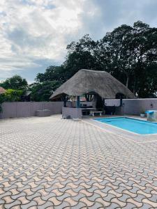 a hut with a swimming pool and a tile floor at Awethu Guest House in Richards Bay