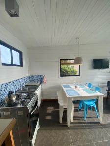 a kitchen with a table and a stove and a dining room at Cabañas Lovel-Van in Curanipe