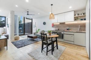 Il comprend une cuisine et un salon avec une table et des chaises. dans l'établissement Stylish One BD Hideaway in Essendon, à Melbourne