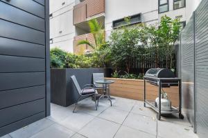 patio ze sprzętem do grillowania, krzesłami i stołem w obiekcie Stylish One BD Hideaway in Essendon w Melbourne