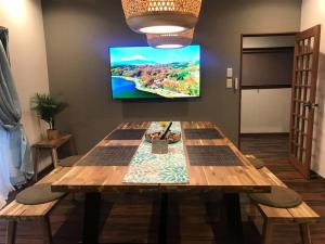 a room with a wooden table with a tv on the wall at HIDAKA STAY VILLA 柴又 in Tokyo