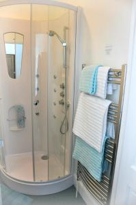 um chuveiro com toalhas num suporte na casa de banho em Gordon House B & B em Tintagel