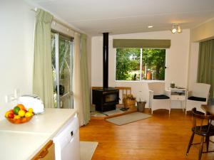 a kitchen and living room with a wood stove at Kea View - Pohara Beach Holiday Home in Pohara