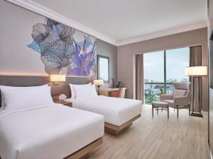 two beds in a hotel room with a painting on the wall at Grand Copthorne Waterfront Hotel Singapore in Singapore +49 photos