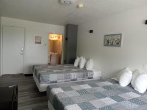 a hotel room with two beds and a door at Cardston Inn in Cardston