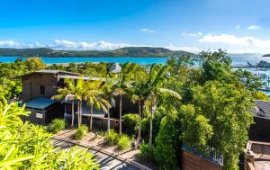 漢密爾頓島的住宿－Point Blue on Hamilton Island by HIHA，享有树木和水景的房屋的空中景致