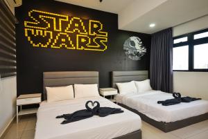 um quarto com duas camas com placas pretas e douradas na parede em Meridin Medini Suite by Nest Home【LEGOLAND】 em Nusajaya