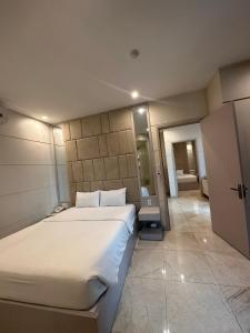 a bedroom with a large bed and a hallway at SANG Hotel Apartment Sai Gon in Ho Chi Minh City