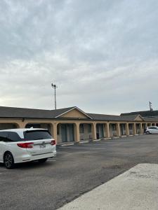 una furgoneta blanca estacionada frente a un edificio en Executive Inn Robstown, en Robstown