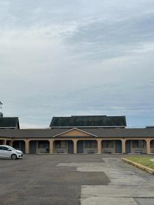 a building with a car parked in a parking lot at Executive Inn Robstown in Robstown